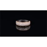 An 18ct white gold, white and cognac diamond band ring set centrally with three rows of round