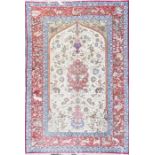 A Persian red and cream ground rug polychrome decorated with stylised flowers and animals, blue