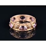 A gilt metal and amethyst bangle the filigree decorated mount evenly set with six oval cut