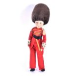 An early 20th century Chad Valley 'Queen's Guard' doll in red felt uniform and bearskin hat, with
