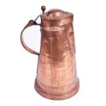 A large Arts & Crafts copper flagon the lid with embossed roundels, curved handle and tapering body,