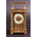 An early 20th century ornate brass carriage clock the white enamel chapter ring with ornately