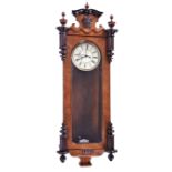 An early 20th century Vienna wall clock the walnut veneered glazed case accommodating a white