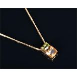 An 18ct yellow gold, peridot, and citrine pendant with a faceted cushion cut citrine beneath a