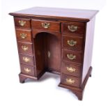 A small mid 18th century walnut kneehole desk the rectangular top with moulded rim over three frieze