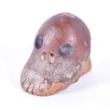 An unusual antique cattle bone carving in the form of a stylised human skull believed to be