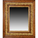 An oak and gilt framed wall mirror ornately decorated with flowers and acanthus, 82 x 70 cm.