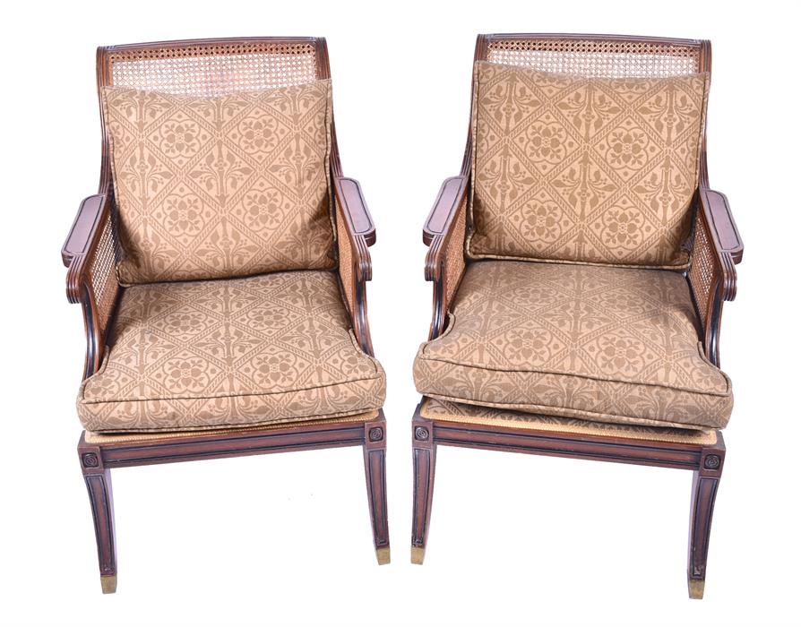 A pair of Regency style bergere library chairs the scrolled and reeded frames, and cane back and