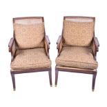 A pair of Regency style bergere library chairs the scrolled and reeded frames, and cane back and