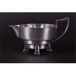 An Arts & Crafts silver plated milk jug by James Dixon & Sons the body of stepped form, supported on