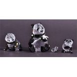 A collection of Swarovski pandas to include an adult panda eating bamboo, approximately 9 cm high,