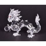 A Swarovski crystal glass Chinese dragon with crystal ball, and red crystal eyes, from Swarovski'