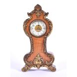 A small late 19th / early 20th century mantle clock set in a walnut veneered case with scrolling