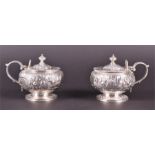 A pair of George III silver repousse mustard pots London 1799, decorated with chased and embossed