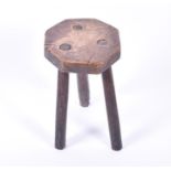 A 19th century country-made rustic octagonal elm-topped milking stool.