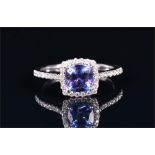 A 14ct white gold, diamond, and tanzanite halo ring set with a cushion-cut tanzanite of