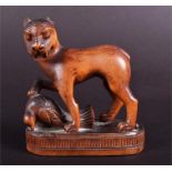 A late 19th century Chinese carved wooden study of a dog standing over it's prey the snarling