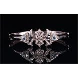 A white metal, diamond, and aquamarine bangle the open-work mount set with round brilliant cut