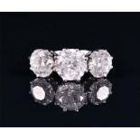 A large and impressive diamond ring set with three round brilliant cut diamonds of approximately 7.0