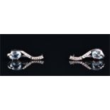 A pair of 14ct white gold and blue topaz drop earrings each set with an oval cut topaz on an