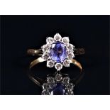 An 18ct yellow gold, diamond, and tanzanite ring set with an oval cut tanzanite of approximately 0.