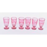 A set of six etched pale cranberry glasses depicting forest and hunting scenes.