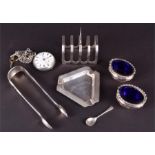 A small silver toast rack together with various other silver items to include a pair of sugar tongs,