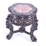 A small late 19th century Chinese carved hardwood and stone topped jardiniere stand supported on