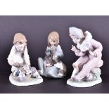 Two Lladro figurines to include a small girl playing with a kitten and puppy, a young girl playing