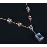 A 9ct yellow gold, diamond, and blue topaz necklace suspended with a large emerald cut topaz of