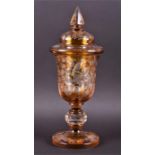 A 19th century Bohemian amber glass goblet and cover with etched decoration depicting birds