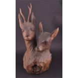 An early 20th century Black Forest carving of a stag and doe the heads carved from one piece of wood