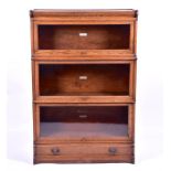 An oak Globe Wernicke bookcase in three sections with glazed sliding doors.