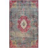 An old Eastern wool work rug the central green field interspersed with a central medallion in shades