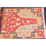 A brightly coloured geometrically patterned runner in red, orange and green, 79 x 304 cm.