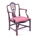 A 19th century mahogany Hepplewhite style elbow chair the pierced back with carved harebells, and