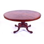 A Victorian mahogany loo table the oval top with moulded rim, over a turned column to four