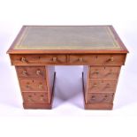 A late 19th century walnut veneered pedestal desk with an inset tooled green leather top of small