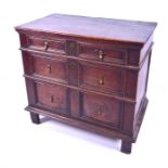 A late 17th or early 18th century oak chest of three long graduated drawers, with panelled fronts