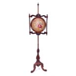 A Victorian carved rosewood pole screen the circular panel with bare twist sides and inset with