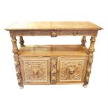 A large Victorian oak serving table the top with carved rim over two drawers with bold lions head