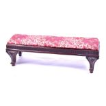 A small 19th century French mahogany foot stool with drop-in pad, supported on four carved