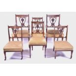 An Edwardian mahogany inlaid salon suite comprising two carver chairs, two single chairs, and two