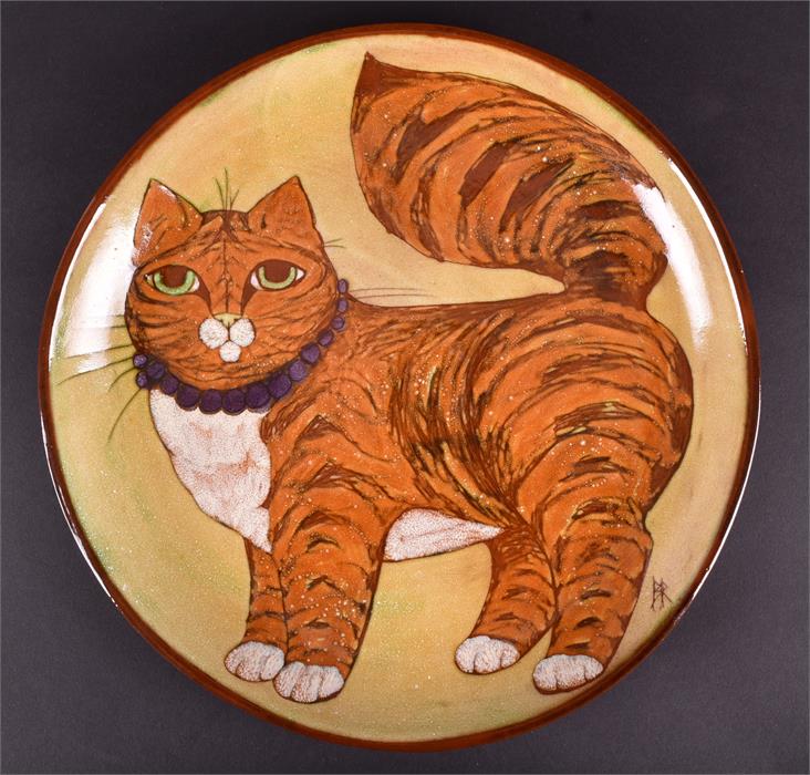 A studio pottery low bowl by Barbara Ross decorated with a plump ginger cat wearing a purple