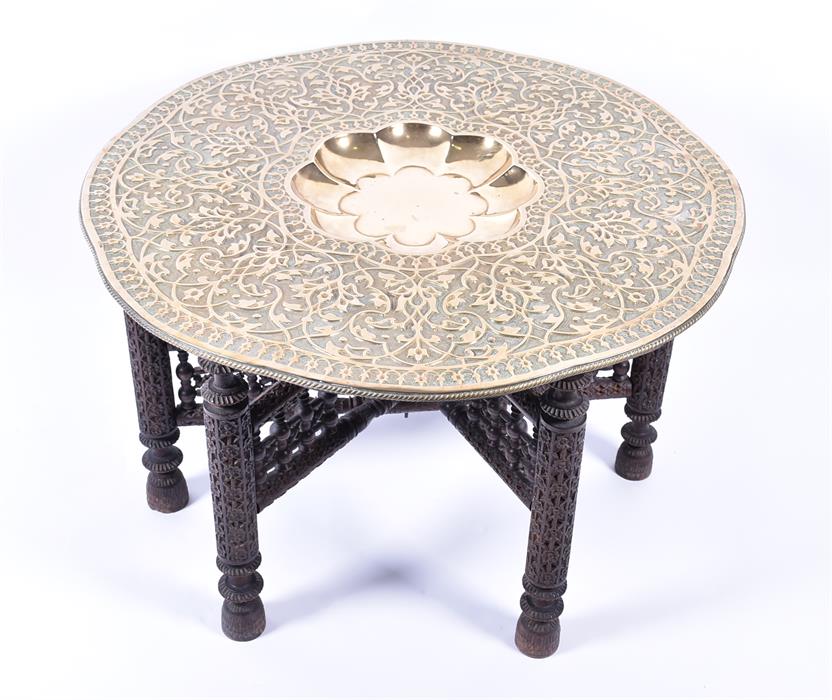 A 20th century Benares brass tray topped table the shaped circular top with scrolling foliate
