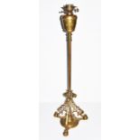 A Victorian brass standard lamp the tripod base with pierced scrolling framework terminating in