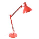 A 1970s Anglepoise-style sprung and angular desk lamp finished in red, with weighted base, the