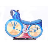 A mid-20th century painted wood fairground ride motorcycle seat finished in blues, yellow, red,
