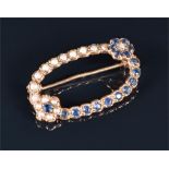 A 9ct yellow gold, sapphire, and split seed pearl brooch the openwork oval mount decorated with