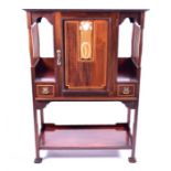 An Art Nouveau mahogany music cabinet the panel door inlaid with mother-of-pearl, opening to